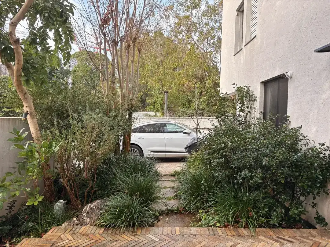 שביל אבן בין ערוגות בגינה כפרית